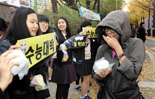 시험에 합격하기를 바라는 마음을 담아 엿을 선물하고 있어요. 옛날 과거 시험장 앞에도 엿을 주고 받는 사람이 많았대요