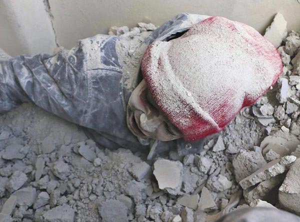 건물이 부서지면서 하얀 콘크리트 가루에 뒤덮인 시리아 소년의 모습.