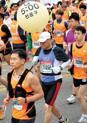 춘천마라톤에 참가한 페이스 메이커가 선수들과 함께 달리고 있어요. 