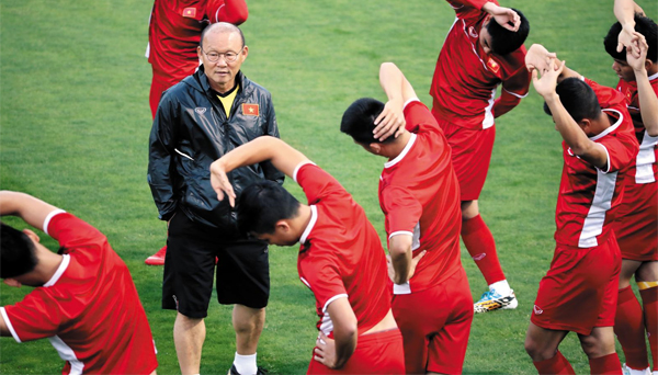박항서(왼쪽에서 둘째) 베트남 축구대표팀 감독이 몸을 푸는 선수들을 지도하고 있어요. 그는 베트남을 스즈키컵 우승으로 이끌며 리더십을 보여줬어요. 
