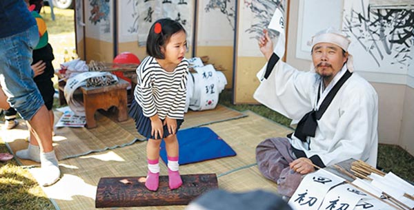 지난해 열린 대전효문화뿌리축제에서 한 소녀가 '불효자 회초리 체험'을 하고 있어요.