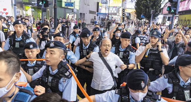 천안문 사건 34주기를 하루 앞둔 지난 3일 홍콩 코즈웨이베이에서 경찰이 한 시민을 연행하고 있어요. /AP 연합뉴스