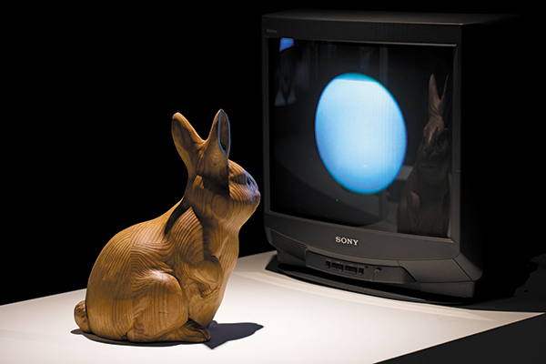 나무 토끼 조각이 TV 모니터에 떠있는 달을 우두커니 바라보고 있어요. 비디오 아티스트 백남준이 1996년 만든 설치 예술 작품 ‘달에 사는 토끼’. /백남준아트센터