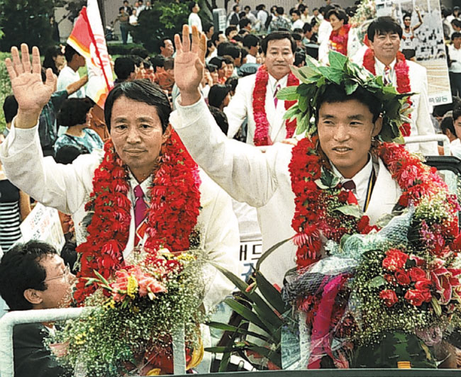 1992년 바르셀로나 올림픽 마라톤 종목에서 금메달을 딴 황영조(오른쪽) 선수가 자신을 환영해주는 시민들에게 인사하고 있어요. /조선일보DB
