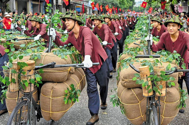 승전 70주년 기념행사에서 참가자들이 전투에 필요한 식량과 군수품 수송을 묘사한 자전거를 끌고 행진하고 있어요. /AFP 연합뉴스